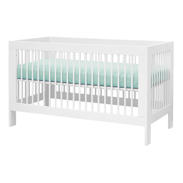 Lit bébé à barreaux évolutif 70x140 avec sommier réglable blanc en bois massif et panneaux de particules, style classique de marque Pinio, disponible chez Jurassien