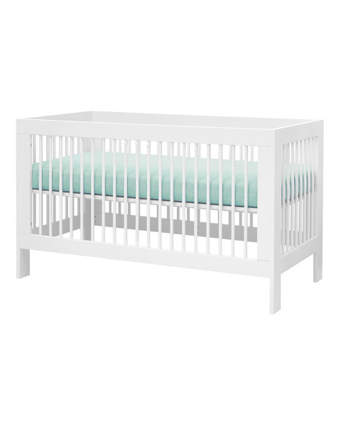 Lit bébé à barreaux évolutif 70x140 avec sommier réglable blanc en bois massif et panneaux de particules, style classique de marque Pinio, disponible chez Jurassien