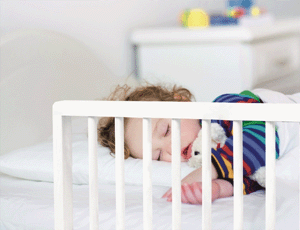 Barrière de lit bébé avec un enfant endormi